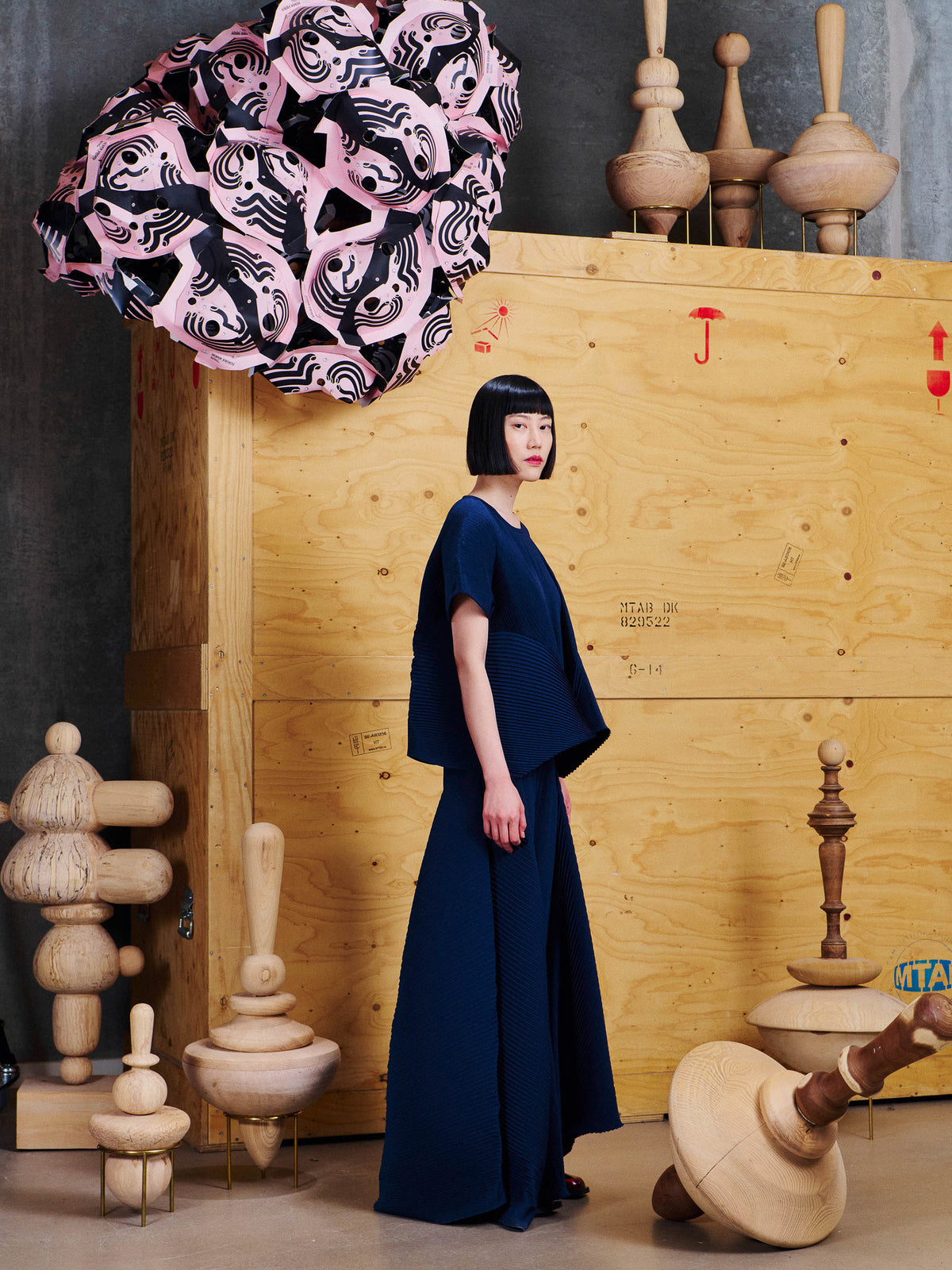 Side view of model wearing the Henrik Vibskov Wrist Plisse Pants in Dress Blue, showing the flowing asymmetric panels and pleated construction.