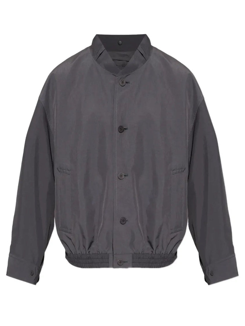 Front view of the Homme Plissé Issey Miyake January Carrier Carried Blouson in charcoal, featuring a high neck, front button closure, side pockets, and straight elastic hem.