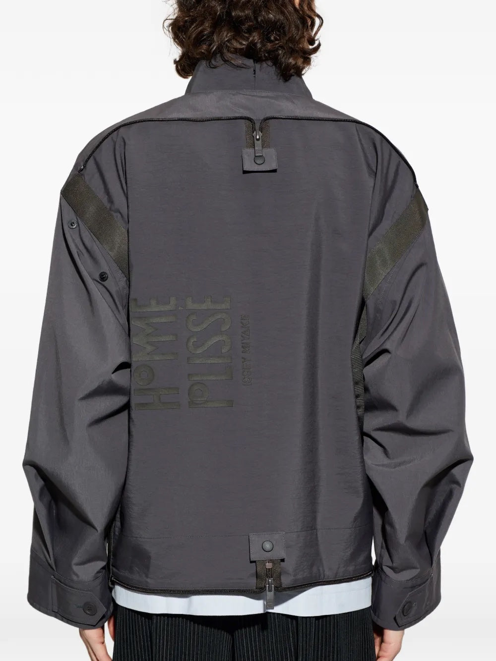 Back view of the male model wearing the charcoal blouson, showing the clean back panel, structured shape, and elastic hem detail.