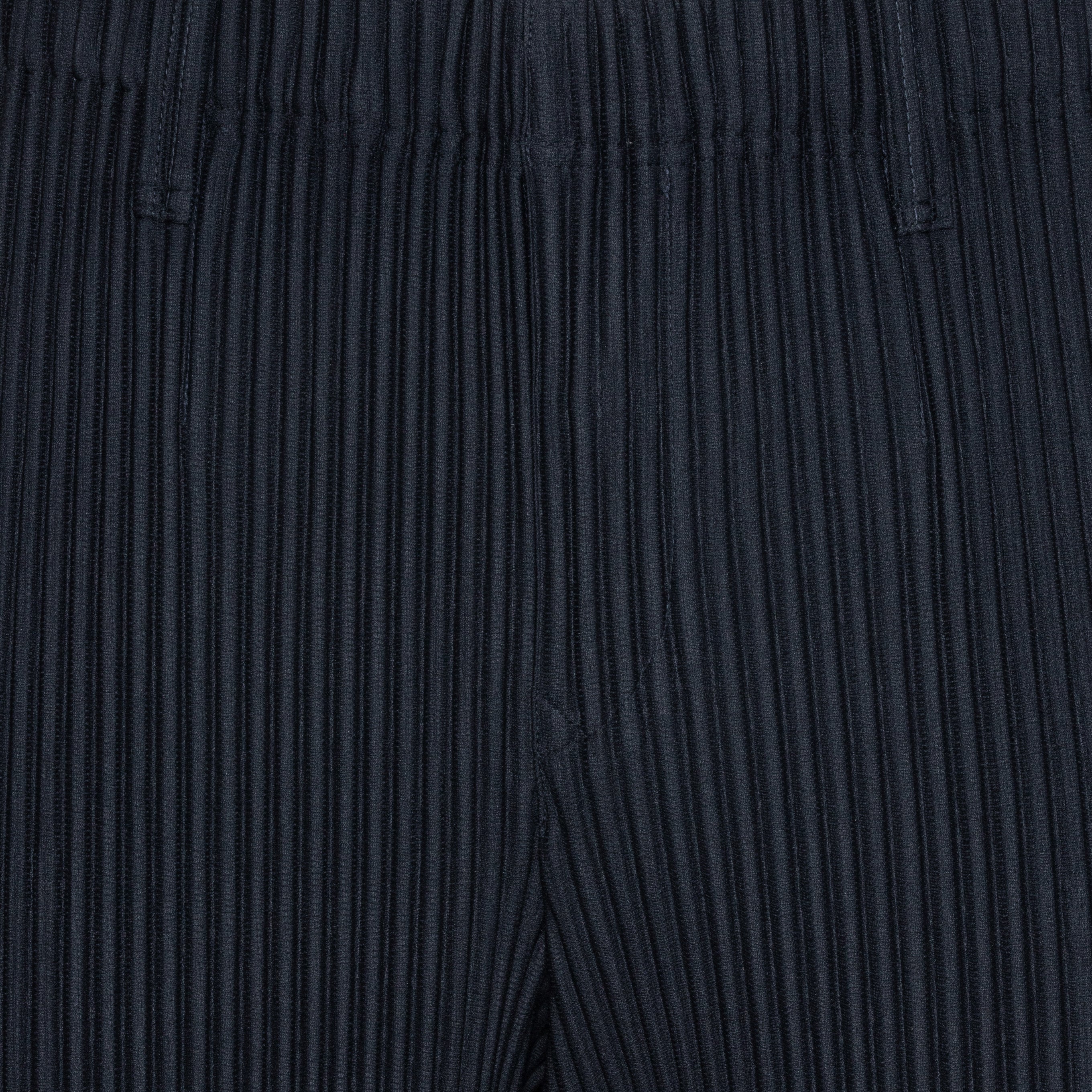 Close-up of the navy plissé pants with straight legs from Issey Miyake Homme Plissé