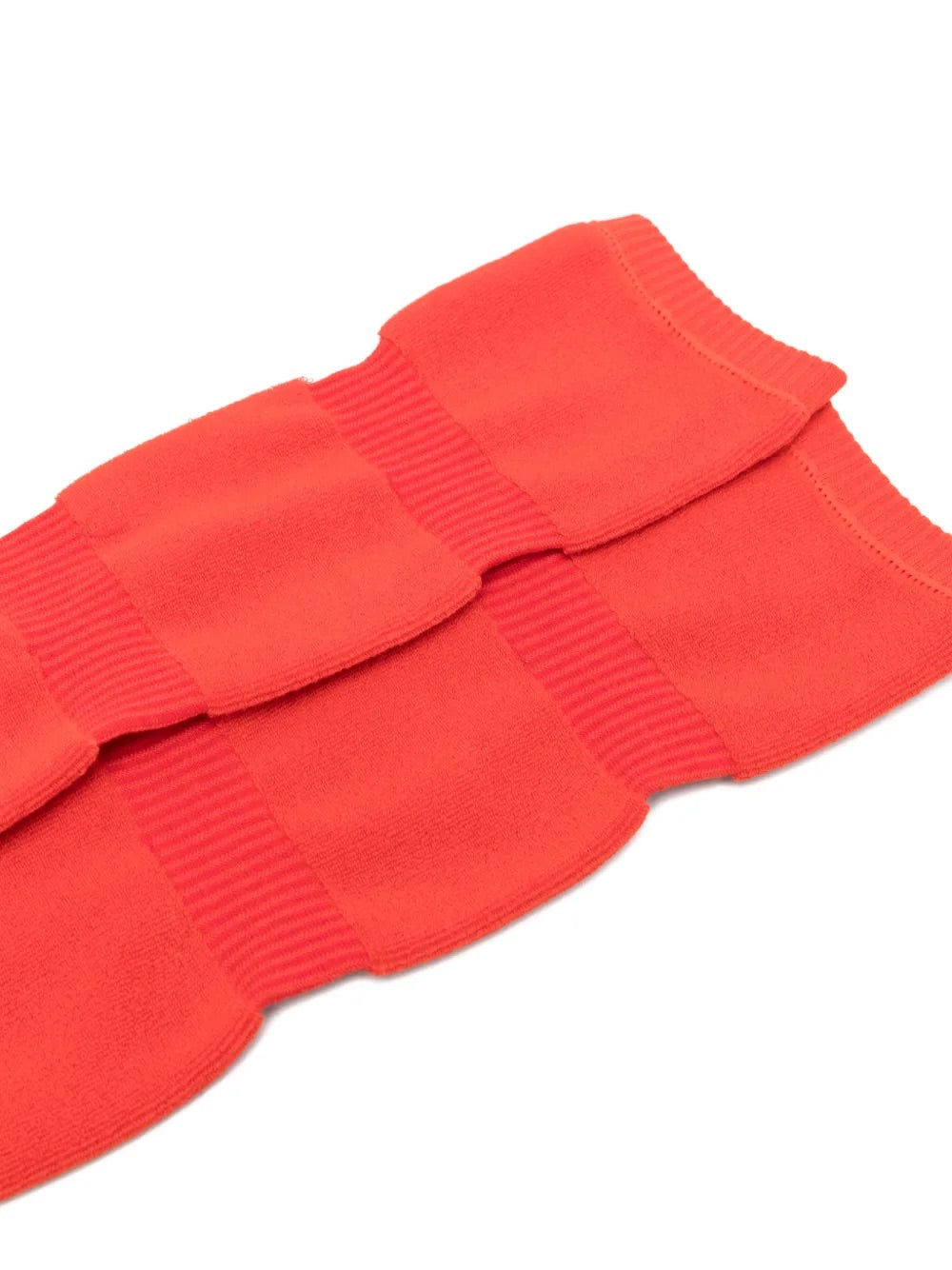 Closeup of Issey Miyake October AW25 Pumped Socks Long in red, highlighting ribbed texture and elasticated over-the-knee cuff.