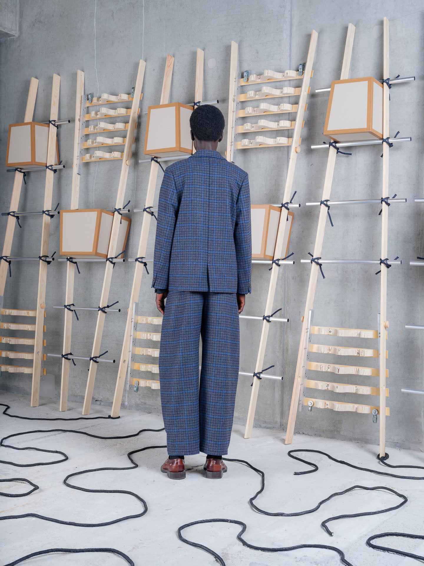 Model wearing Henrik Vibskov Lonely Blazer in Blue Wool Checks, back view.
