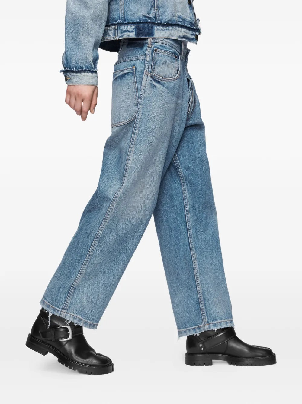 Side view of a male model wearing the Maison Margiela Pants 5 Pockets in Washed Blue, emphasizing the straight-leg silhouette, raw-cut hem, and clean side profile of the jeans.