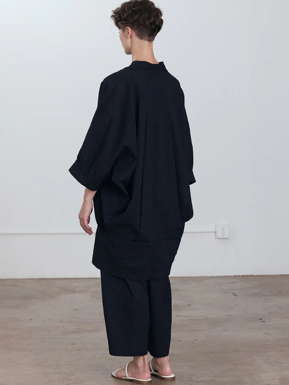 Black Crane Spoon Jacket in Midnight - three-quarter view on model showing balloon sleeve and panelled front pockets