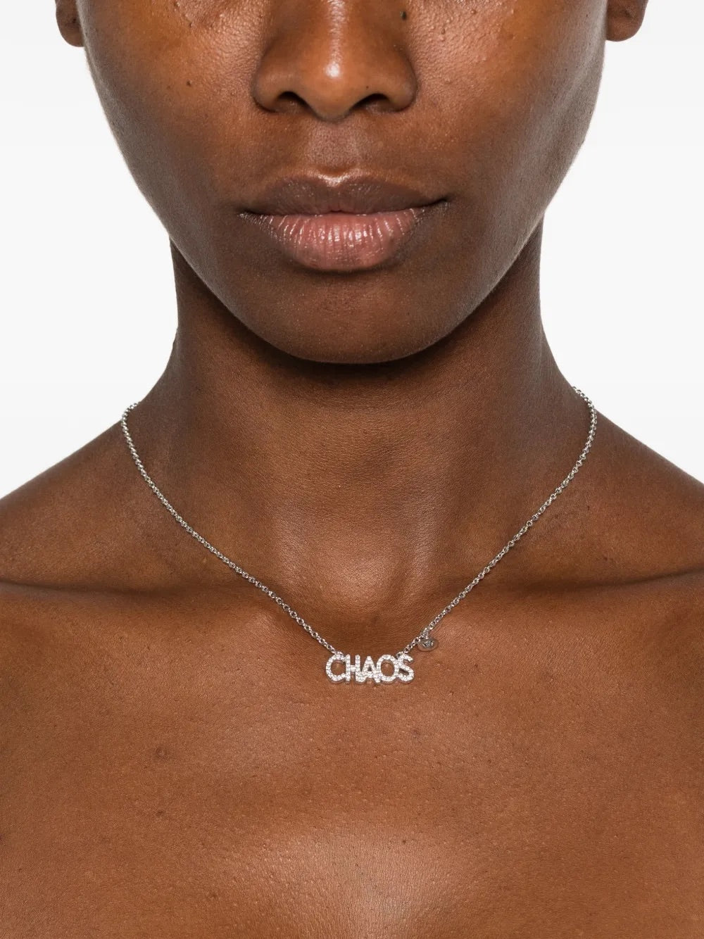 Vivienne Westwood Chaos Pendant in Platinum, worn on model with fine chain and CHAOS lettering pendant at the centre