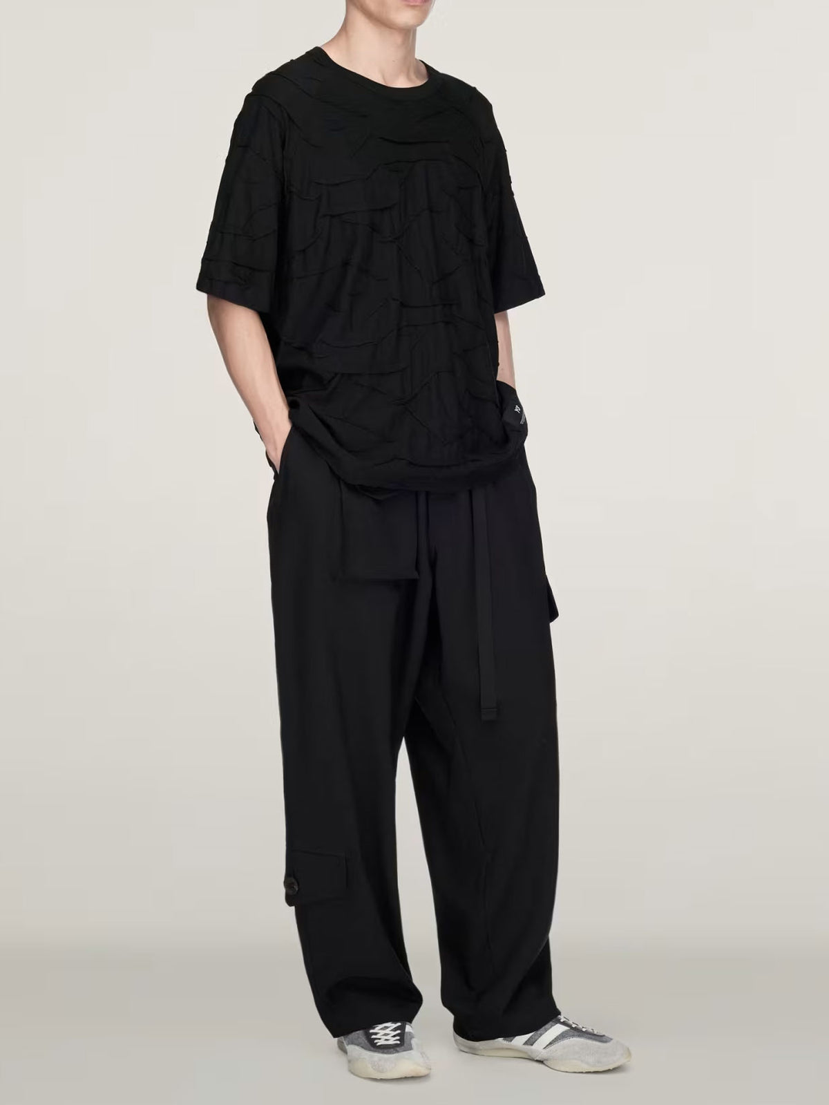 Full-length model view wearing the Y-3 Pleated Short Sleeve Tee in black with wide trousers, showing the relaxed everyday silhouette.